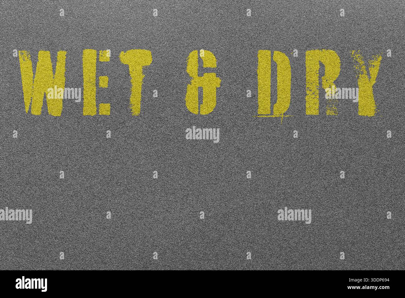 Papier de verre noir mouillé et sec à grain fin avec les mots Wet and DRY gravés au pochoir sur fond jaune. Banque D'Images