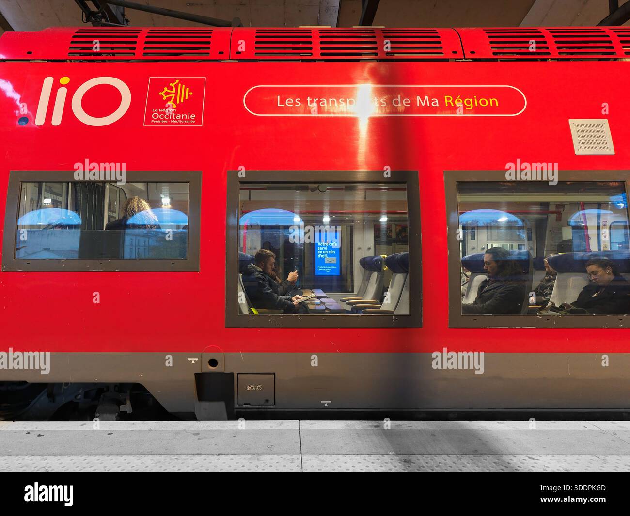 Passagers dans un train régional Lio stationné à la gare de Nîmes, France. Banque D'Images