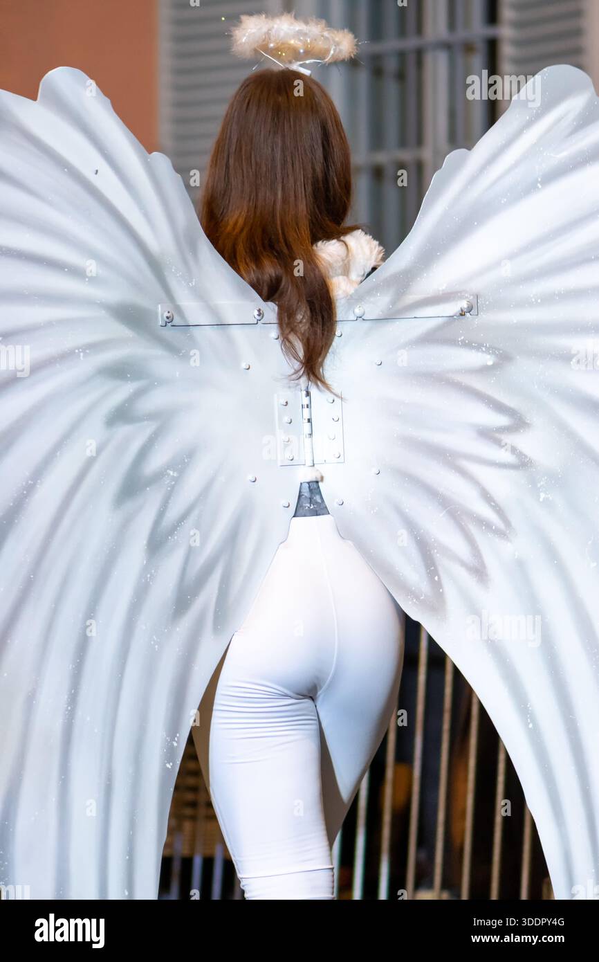 Un participant habillé comme un ange avec des ailes et un halo fait partie du festival Banque D'Images
