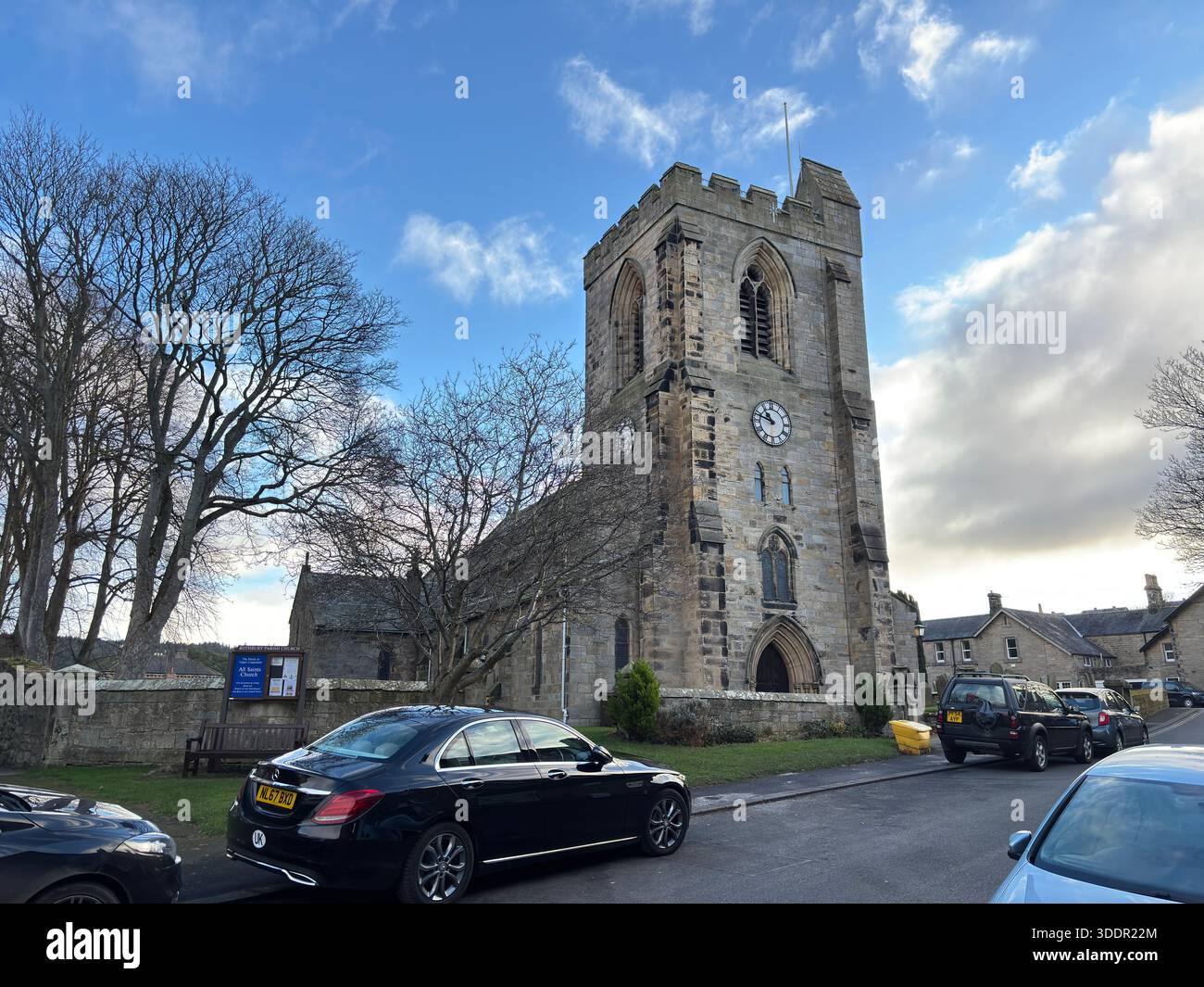 Bâtiment historique en pierre de l'église All Saints dans le village de Rothbury en Angleterre avec nef, tour et détail architectural. Banque D'Images