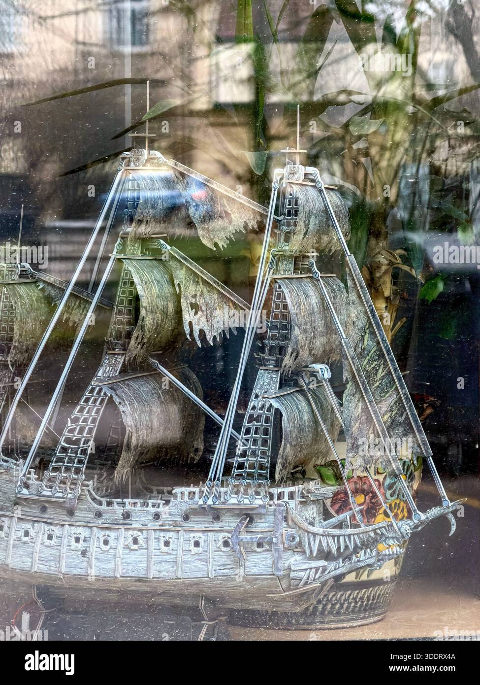 Vilnius, Lituanie, 20 décembre 2025 : un modèle de bateau dans une vitrine près d'une fenêtre à Vilnius réfléchit la lumière. Banque D'Images