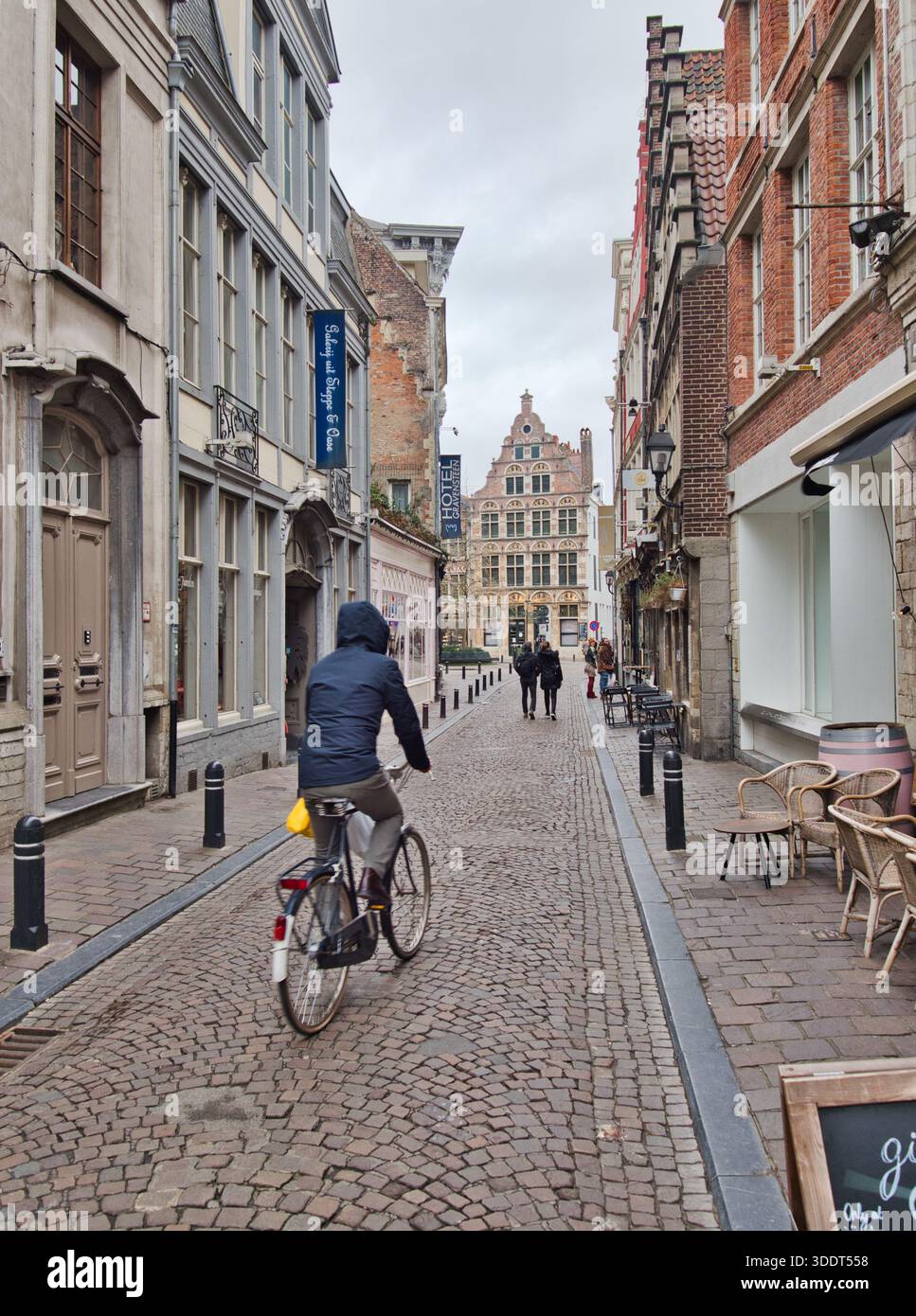 Gand-Flandre-orientale-Belgique-9 février 2020,Un cycliste longe une rue pavée historique étroite au cœur de Gand, en Belgique, avec Traditi Banque D'Images
