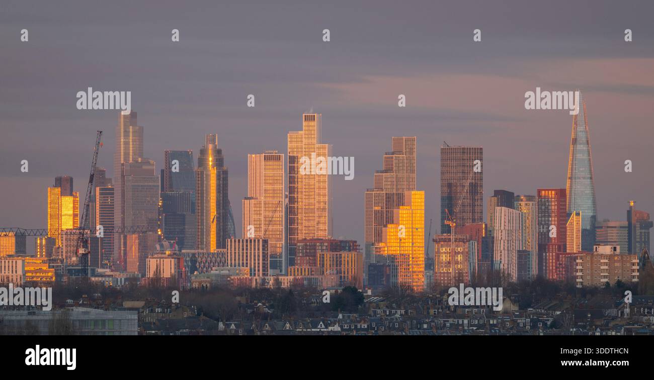 Wimbledon, Londres, Royaume-Uni. 3 janvier 2026. Panorama des gratte-ciels de la ville de Londres brillants or au coucher du soleil avec des propriétés résidentielles de faible hauteur au premier plan. Crédit : Malcolm Park/Alamy Live News Banque D'Images