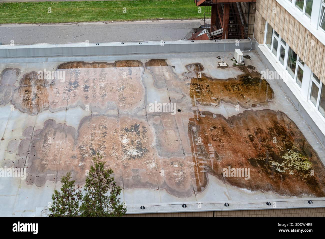 Accumulation d'eau stagnante sur la membrane du toit plat montrant un mauvais système de drainage sur le bâtiment résidentiel, vue aérienne propre du toit engorgé d'eau. Banque D'Images