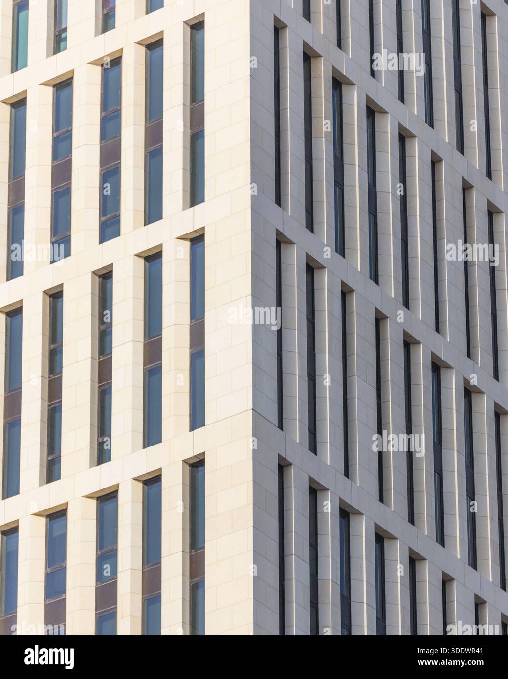 Doha, Qatar - 21 février 2025 : vue sur la symétrie architecturale d'un bâtiment moderne, avec ses motifs rythmiques de fenêtres créant un captivant Banque D'Images