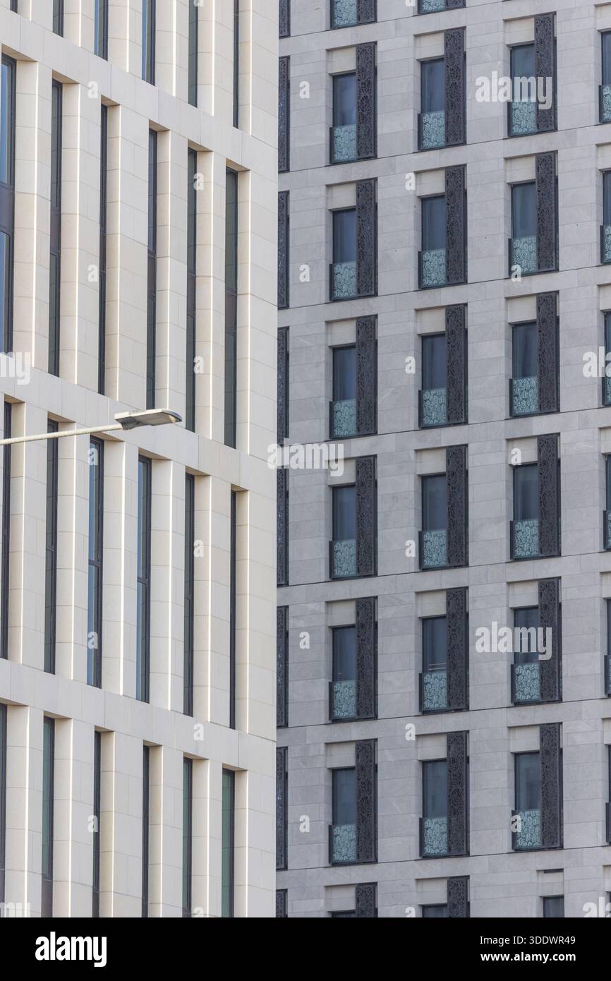 Doha, Qatar - 21 février 2025 : vue sur l'architecture moderne et dure, avec des motifs répétitifs de fenêtres créant un paysage urbain rythmé, le refle de pierre pâle Banque D'Images