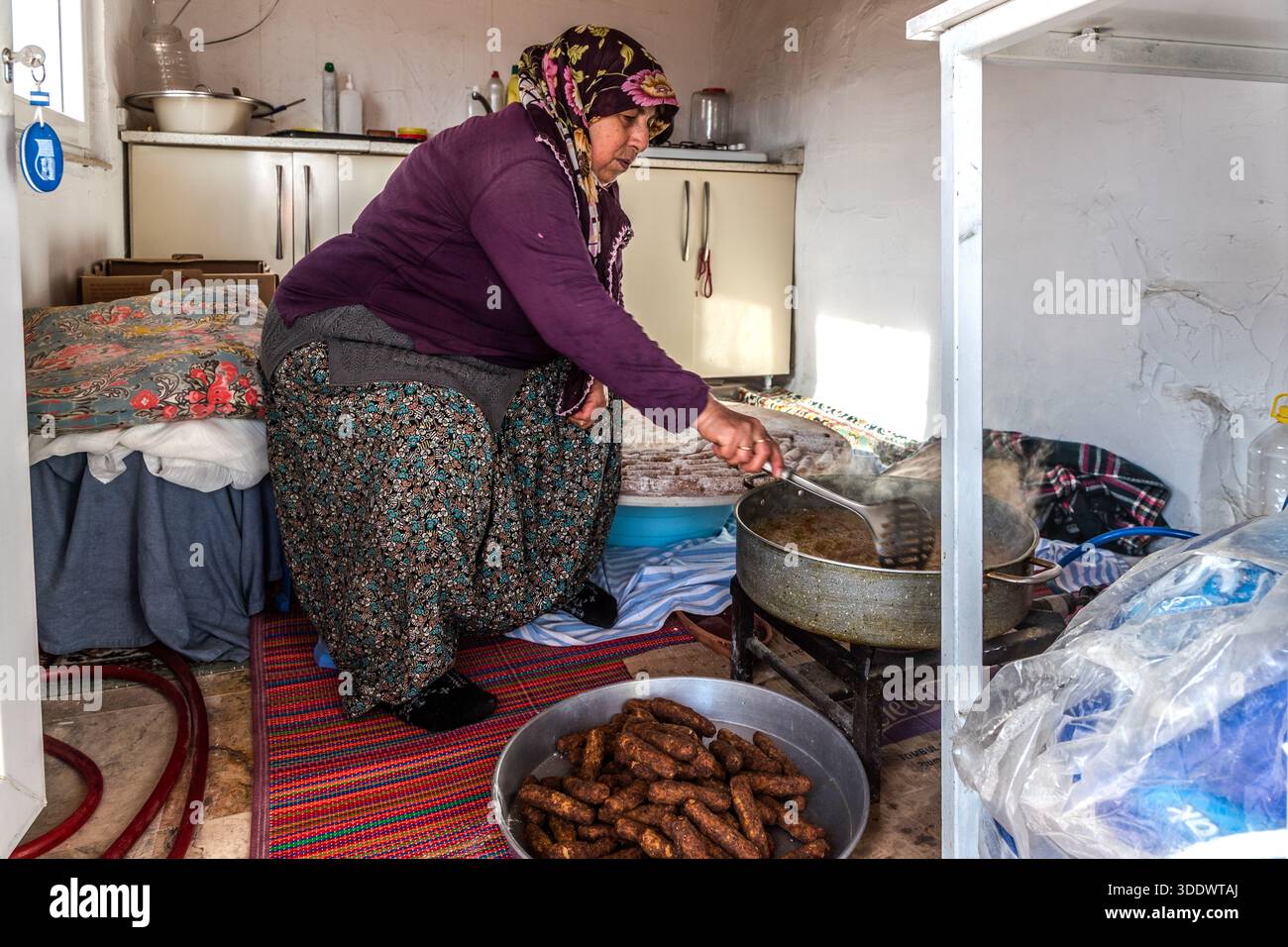 Un cuisinier faisant frire des boulettes de viande hachées appelé Ürgüp Köftesi dans la petite cuisine du restaurant Tık Tık Kadın Emeği. Ürgüp, région d'Anatolie centrale, Turquie Banque D'Images