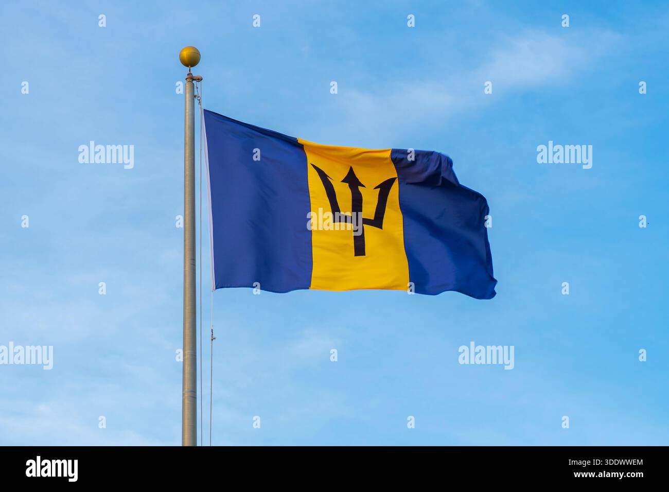 Drapeau national de la Barbade avec fond de ciel bleu à la Barbade. Banque D'Images