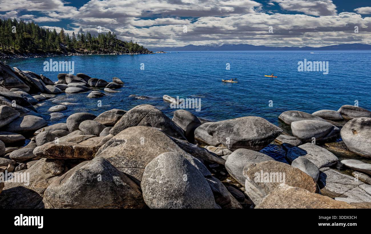 Les kayakistes glissent sur les eaux bleues claires du lac Tahoe, entourés par les pics de granit et les forêts alpines de la Sierra Nevada. La remarqua du lac Banque D'Images