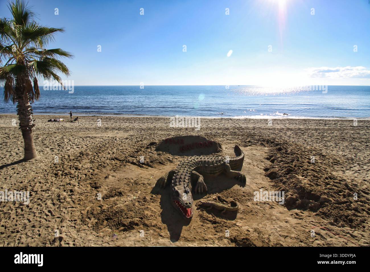 Une sculpture détaillée d'art de sable d'un crocodile sur une plage ensoleillée à Marbella, Costa del sol, Espagne. Banque D'Images