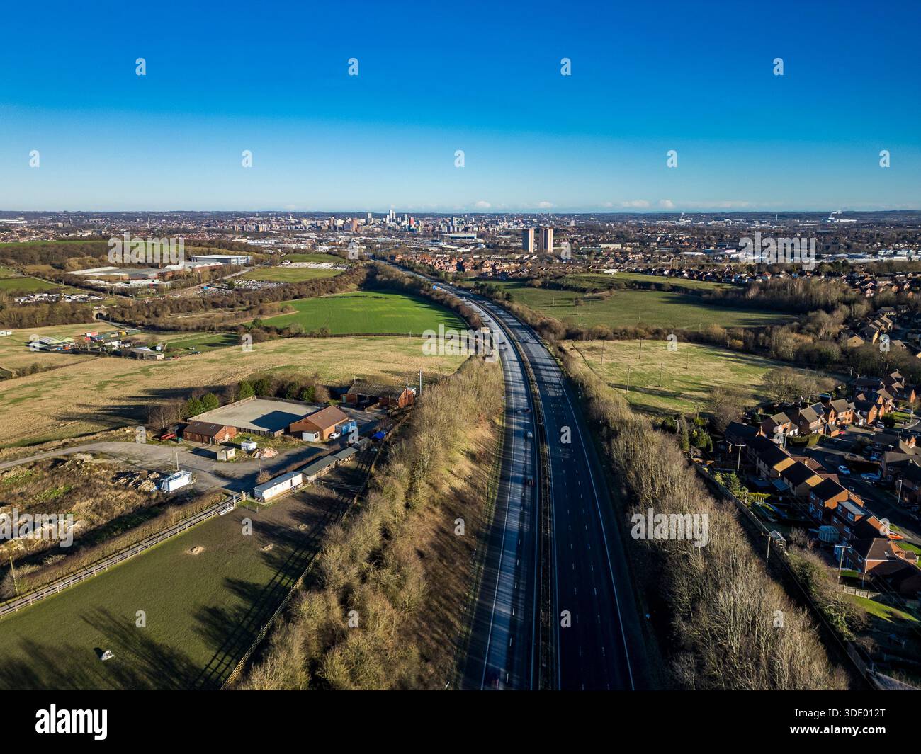 Vue aérienne sur l'autoroute M621 en direction du centre-ville de Leeds, avec des logements de banlieue et des espaces verts dans le West Yorkshire, Royaume-Uni Banque D'Images