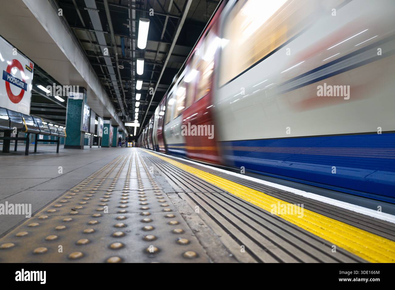 Le train de métro londonien dépasse la plate-forme de la gare. Londres, Royaume-Uni, 3 mars 2024 Banque D'Images