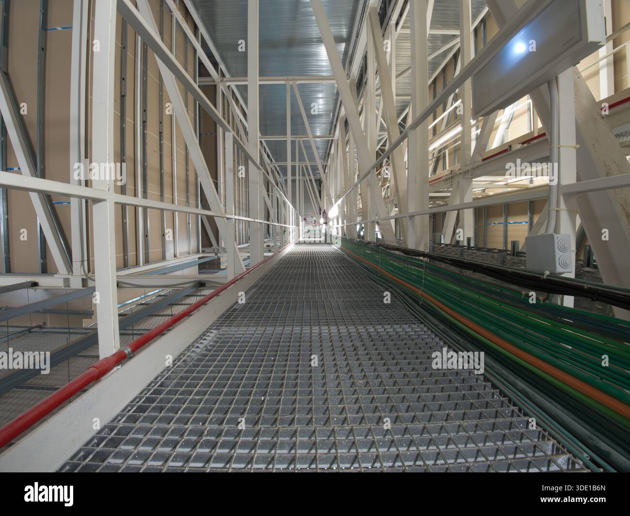 Structure de passerelle en métal industriel Low angle ; Un plan dramatiquement éclairé et à faible angle d'une longue passerelle en métal industriel et d'une structure en treillis, empha Banque D'Images