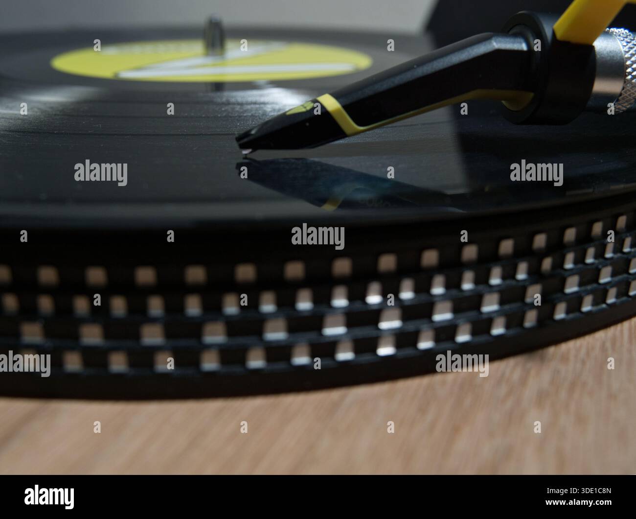 Platine Vintage avec disque vinyle noir ; vue de dessus d'une platine vinyle classique en bois tournant un disque vinyle noir avec une étiquette jaune vif. Captu Banque D'Images