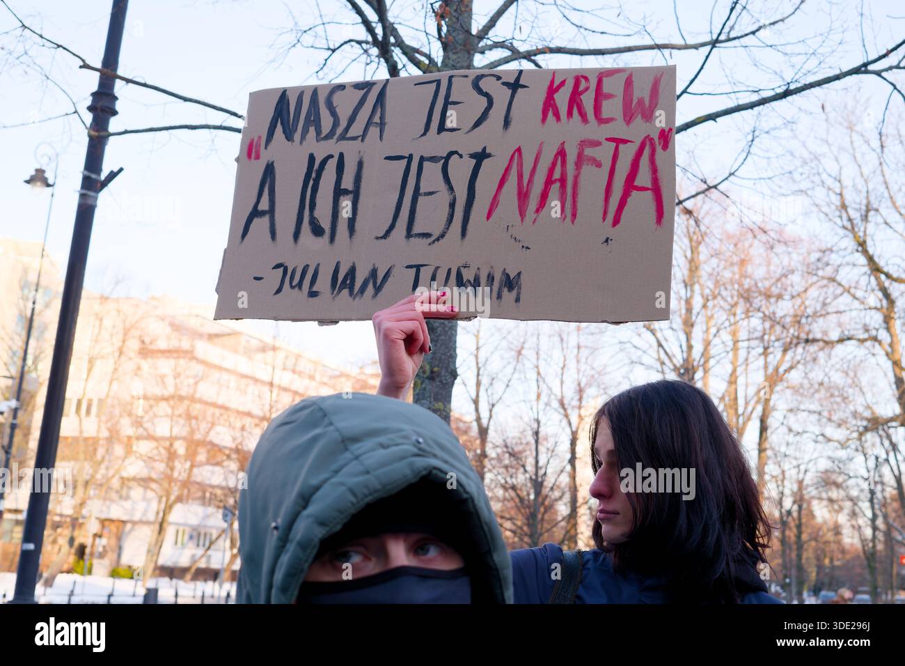 Manifestant tenant une pancarte manuscrite avec une citation du poème de Julian Tuwim 'To the simple Man' lors d'une manifestation près de l'ambassade américaine. Banque D'Images