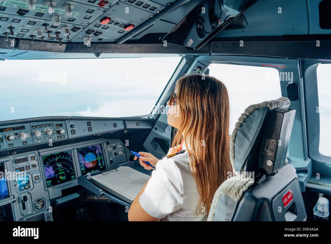 Pilote professionnel féminin travaillant à l'intérieur du cockpit de l'avion Banque D'Images