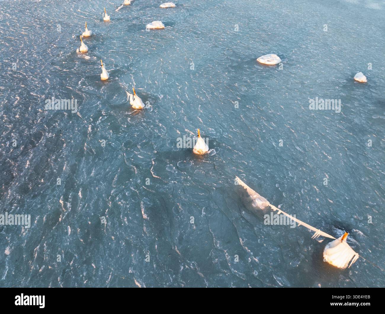 Vue aérienne de bouées de navigation gelées couvertes de glace épaisse et de glaçons dans la mer Baltique, baie de Pärnu, Estonie. Banque D'Images