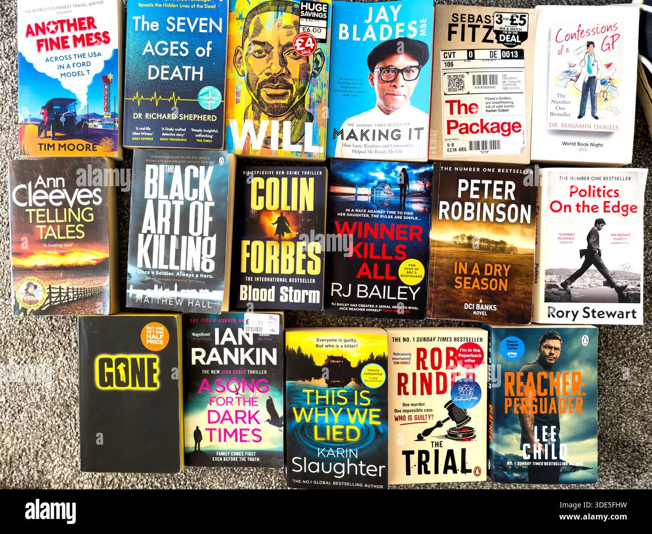 Vue de dessus d'un assortiment coloré de livres de poche médicaux populaires de fiction criminelle et de non-fiction disposés sur une surface plane à la lumière naturelle Banque D'Images