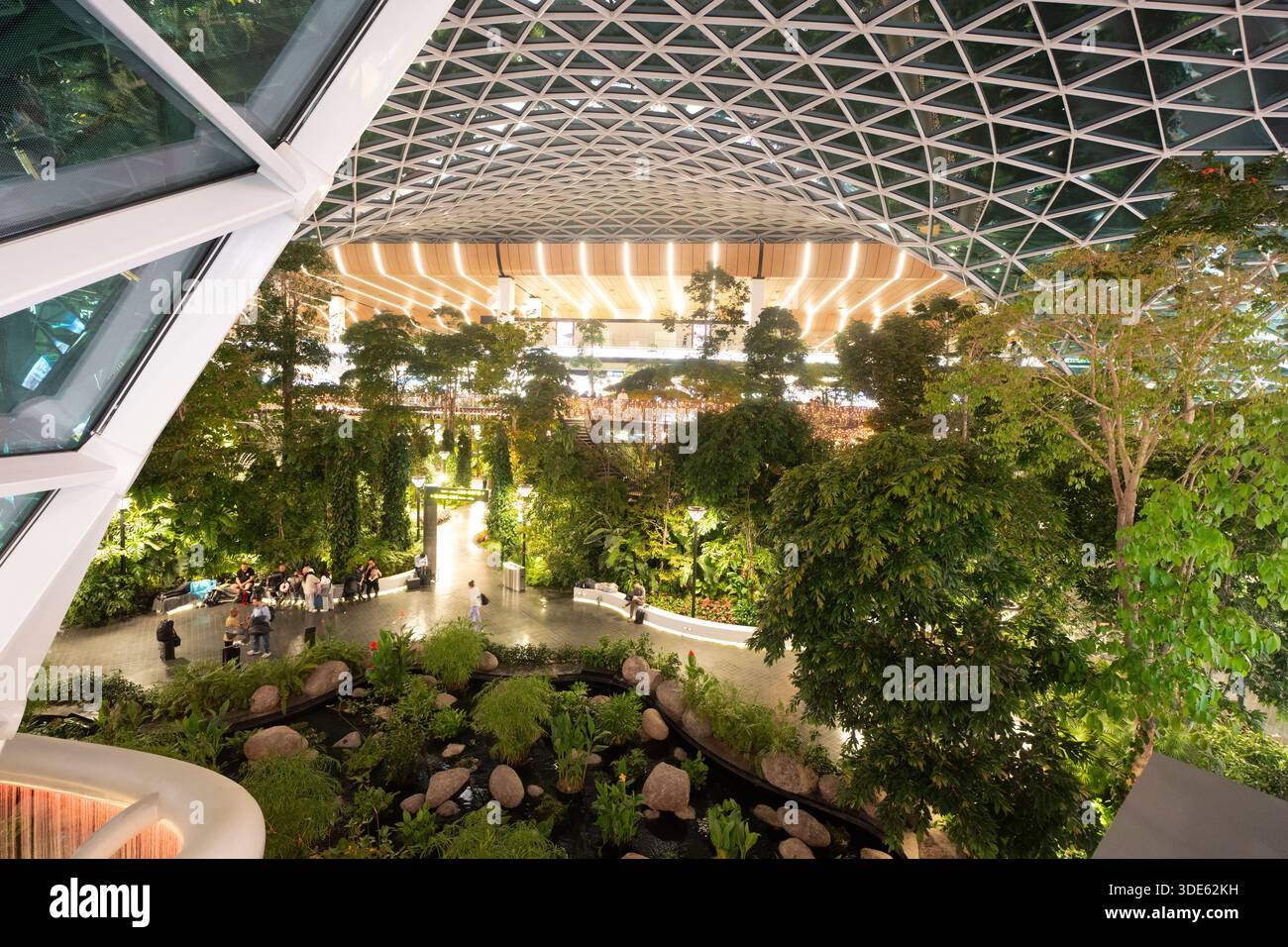 Les gens se détendent au milieu d'une végétation luxuriante à l'aéroport international Hamad de Doha, au Qatar, en profitant de sa forêt intérieure. Banque D'Images