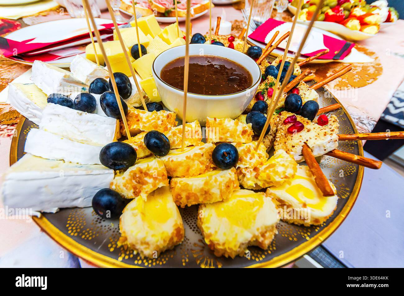 Plateau de fromage festif avec assortiment de fromages, raisins et sauce pour tremper pour les fêtes Banque D'Images