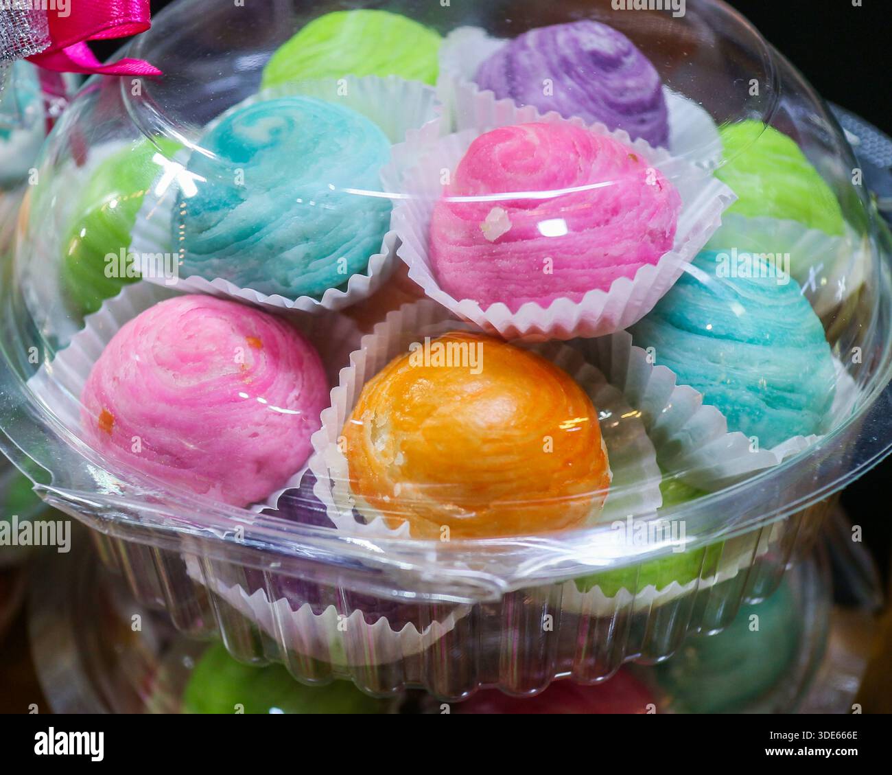 Brioches à pâtisserie chinoise pastel dans un emballage transparent. Gâteaux de lune thaïlandais traditionnels pour des cadeaux festifs et des visuels marketing de boulangerie asiatique. Banque D'Images