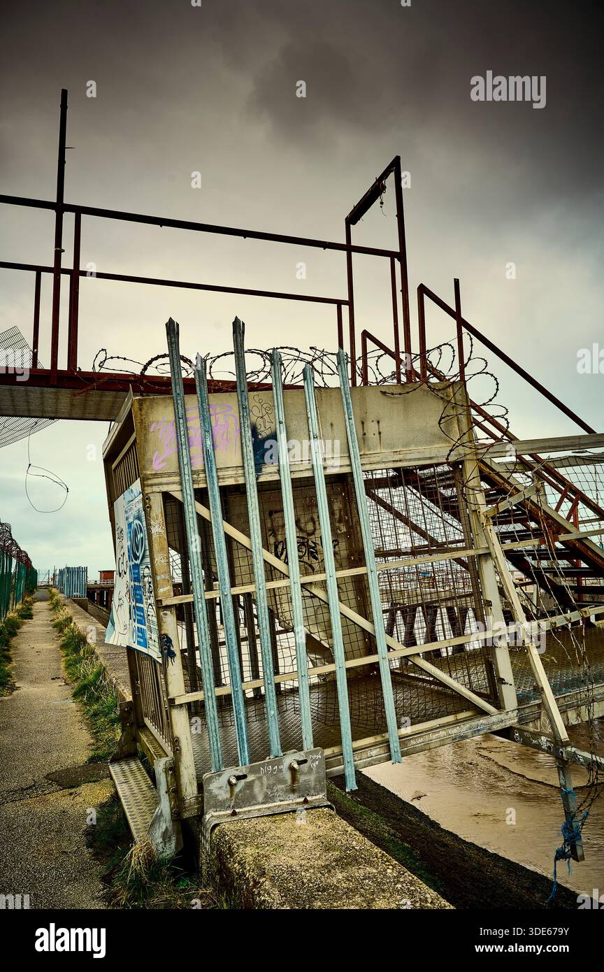 Installation abandonnée et couverte de graffitis en bordure de quai sur les rives de la rivière Wyre à Fleetwood, Royaume-Uni Banque D'Images