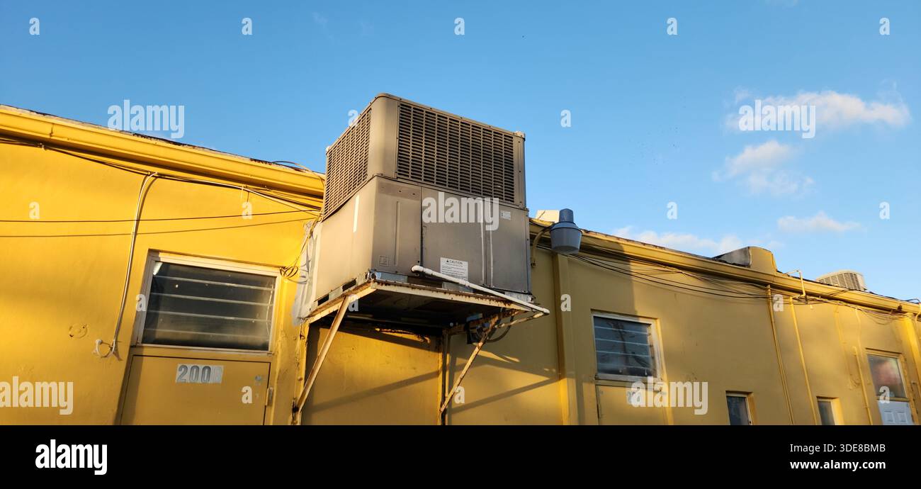 Une unité de climatisation extérieure montrant des signes évidents d'usure et de mauvais entretien, avec des fuites d'eau du système. L'image met en évidence les aspects techniques Banque D'Images
