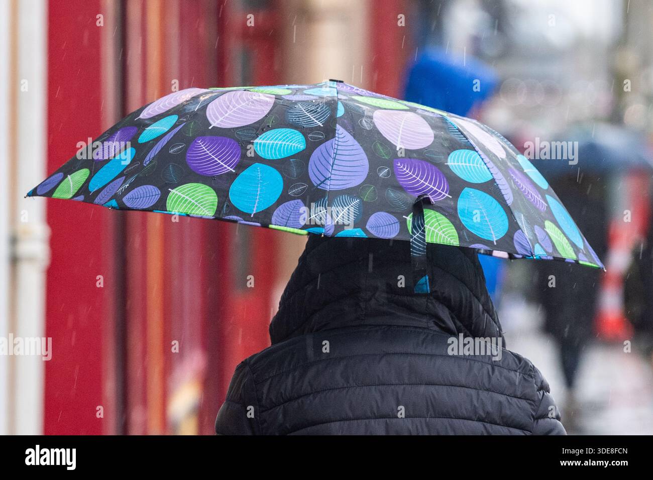 Personne à l'abri de fortes pluies sous un parapluie à Bantry, West Cork, Irlande.. Banque D'Images