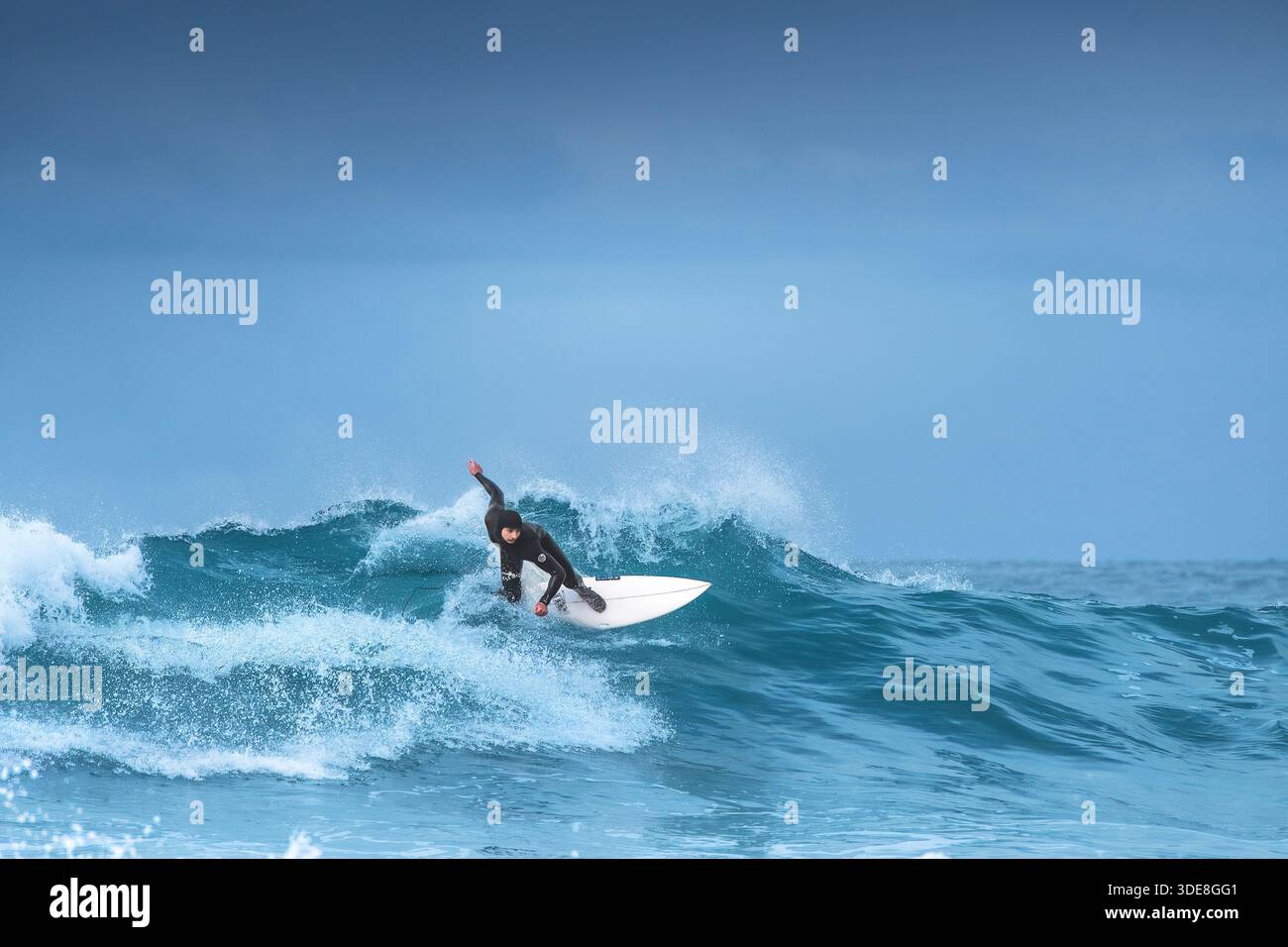 Un surfeur qui fait une vague à Fistral à Newquay, en Cornouailles, au Royaume-Uni. Banque D'Images