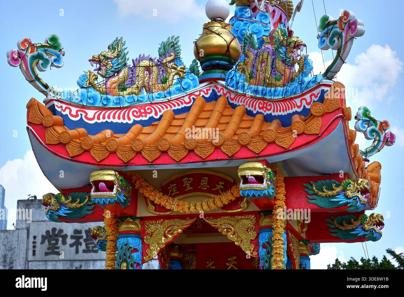 Le toit principal de la passerelle du temple au cimetière Teochew est rempli de dragons, phoenixes, symboles auspicieux au-dessus des piliers rouges, montrant le patrimoine culturel. Banque D'Images