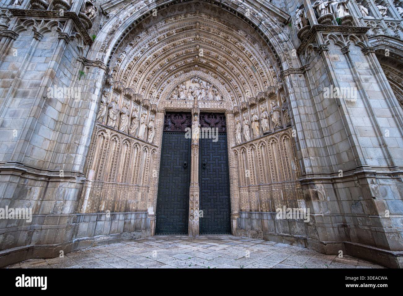 Des sculptures et sculptures complexes en pierre décorent la grande entrée voûtée de la cathédrale historique de Tolède en Espagne. Banque D'Images