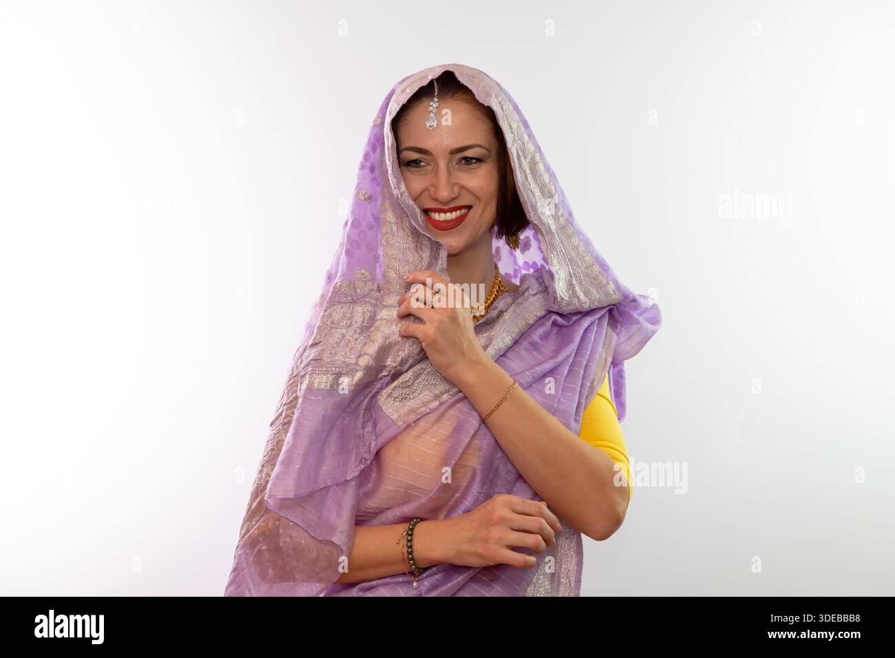 Une femme d'âge moyen dans un sari indien avec la tête couverte de sourires Banque D'Images