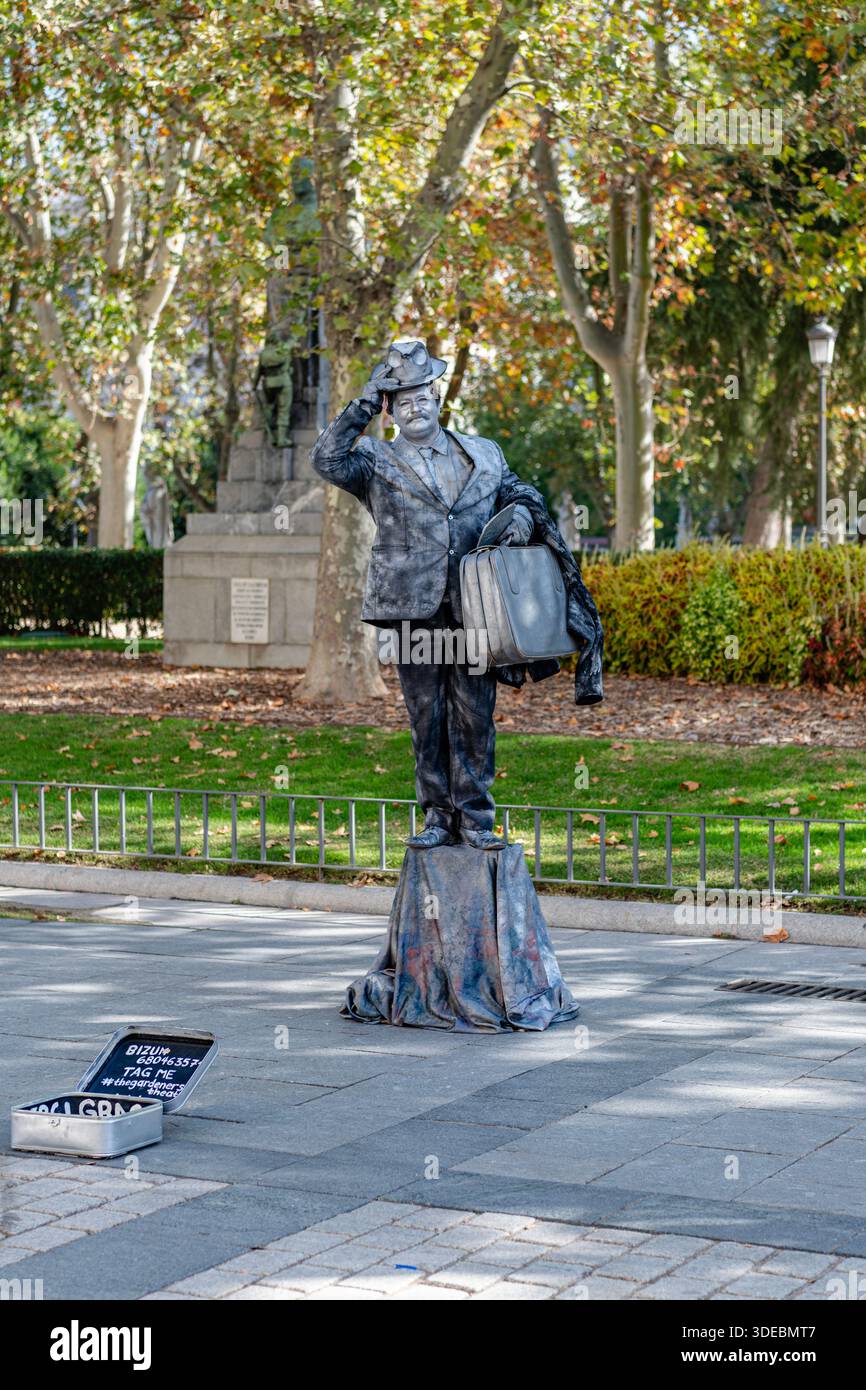 Statue argentée artiste de rue posant avec une valise sur la Plaza de Oriente. Banque D'Images