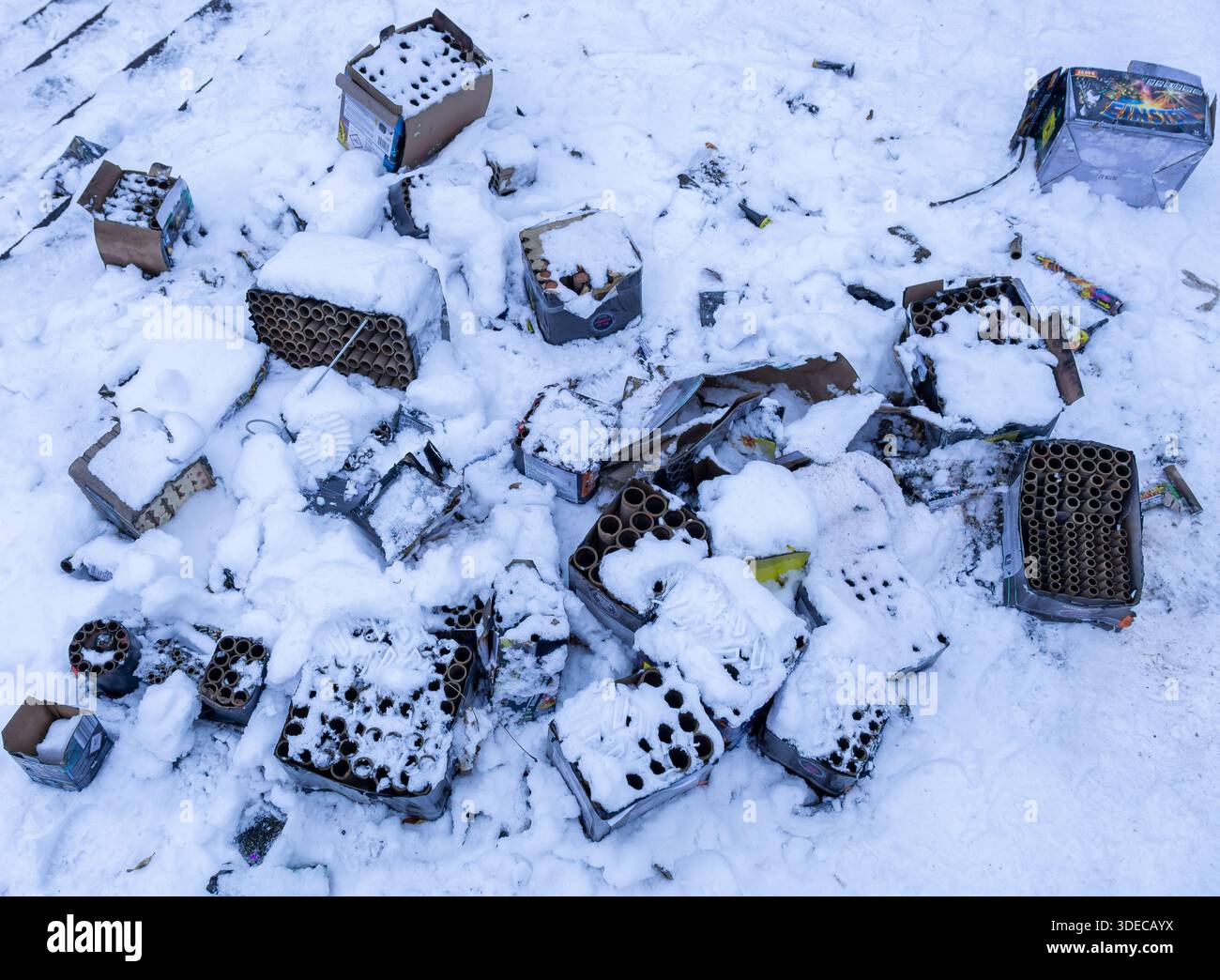 Vue rapprochée des feux d’artifice de la Saint-Sylvestre usagés et jetés dans la neige après les célébrations. Déchets de feux d'artifice enneigés, usage éditorial seulement. Banque D'Images