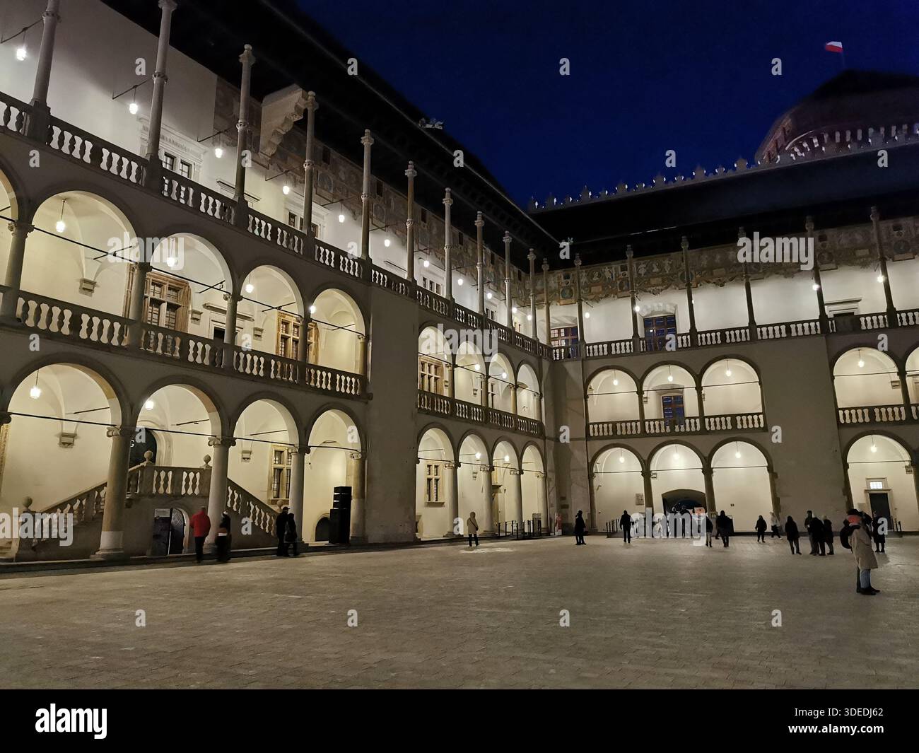 La cour Renaissance du château de Wawel brille par une soirée hivernale fraîche à Kraków - des arches historiques, des lumières et l'architecture royale de Pologne à son meilleur Banque D'Images