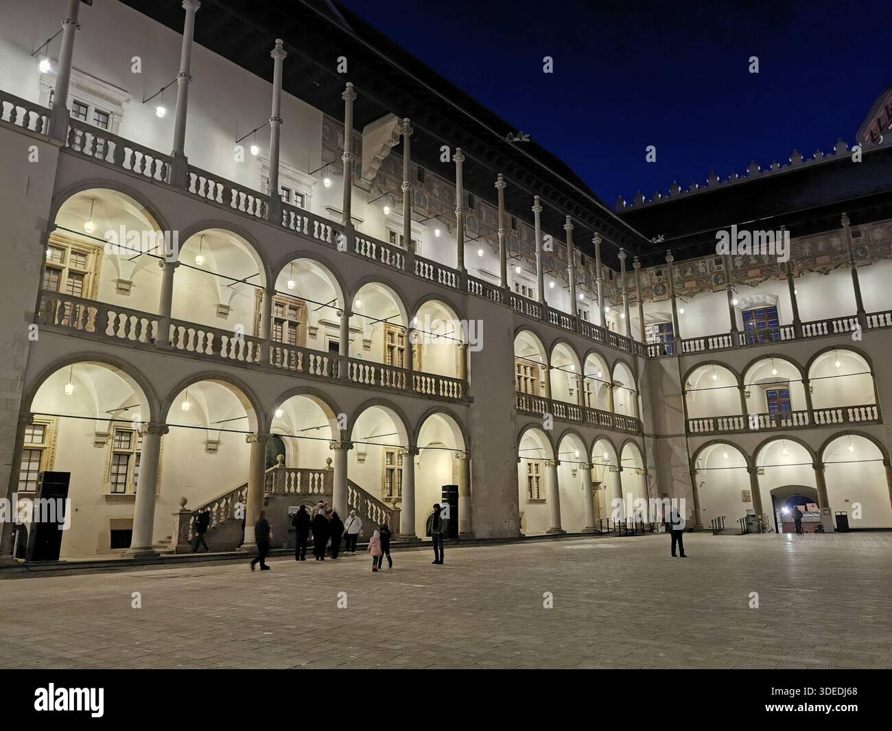 La cour Renaissance du château de Wawel brille par une soirée hivernale fraîche à Kraków - des arches historiques, des lumières et l'architecture royale de Pologne à son meilleur Banque D'Images