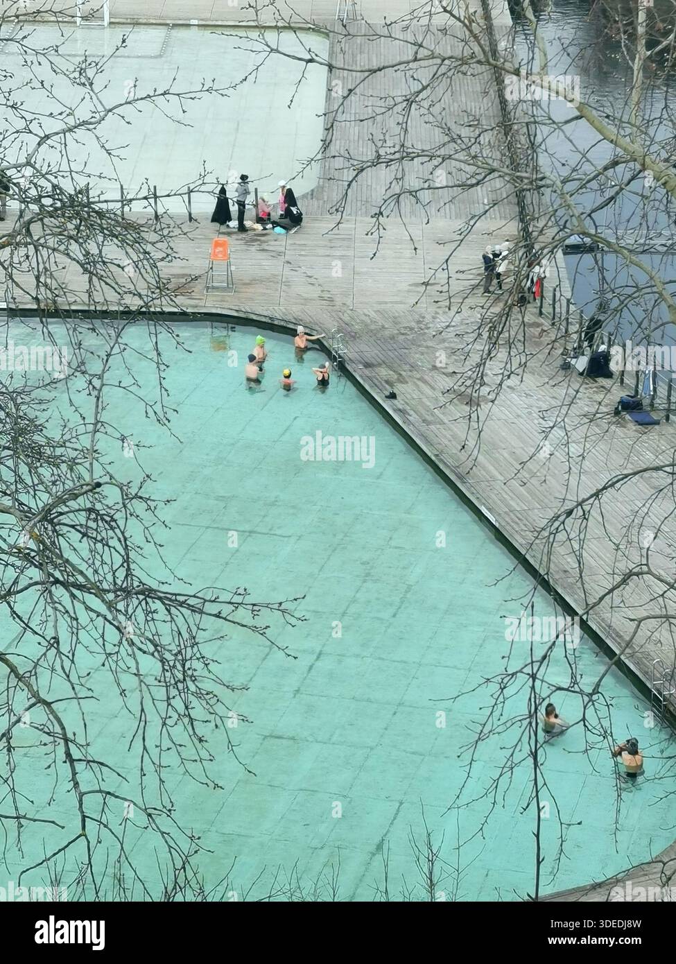 Nageurs d'hiver de niveau inférieur à zéro à Zakrzówek, Kraków bravant les eaux turquoises glacées : baignade en eau froide, aventure en plein air et culture polonaise du bien-être hivernal. - Image de stock capturée avec un smartphone