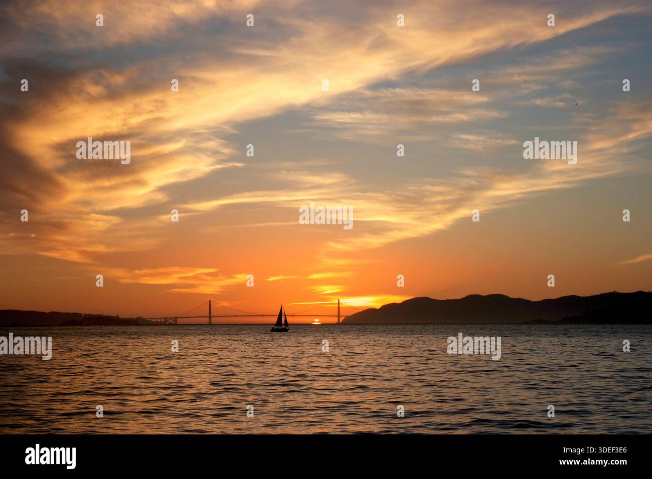 Silhouette d'un voilier passant devant le Golden Gate Bridge au coucher du soleil, San Francisco, Californie, États-Unis Banque D'Images