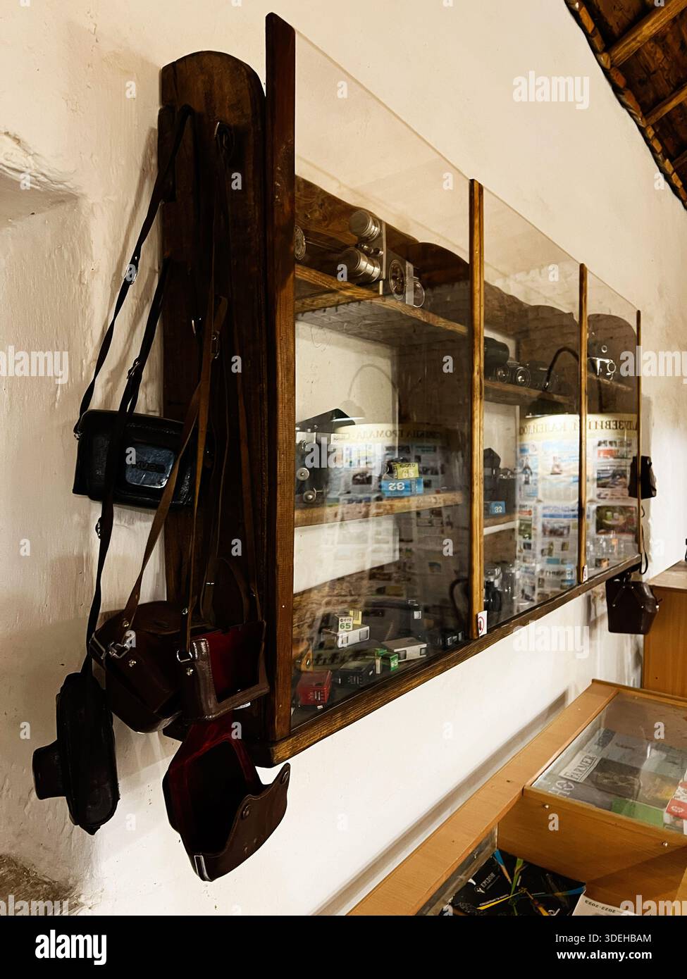 Khodakhkiv, Ukraine - 29 novembre 2025 : scène de magasin de photographie rétro avec une vitrine en verre, des appareils photo vintage et des bracelets en cuir. Banque D'Images