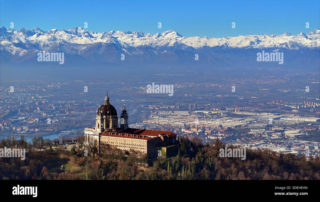 Vue aérienne de la basilique de Superga avec l'horizon de Turin entouré par les Alpes enneigées Banque D'Images