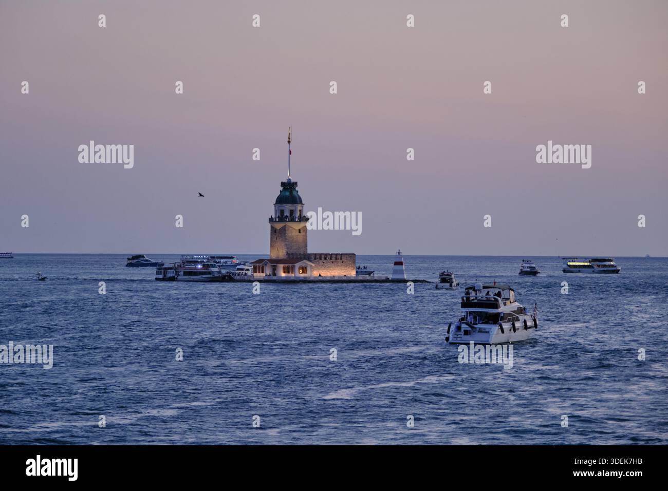 Vue captivante sur l'emblématique Tour de la jeune fille d'Istanbul (Kız Kulesi) illuminée au crépuscule, se dressant majestueusement dans le détroit du Bosphore. Banque D'Images