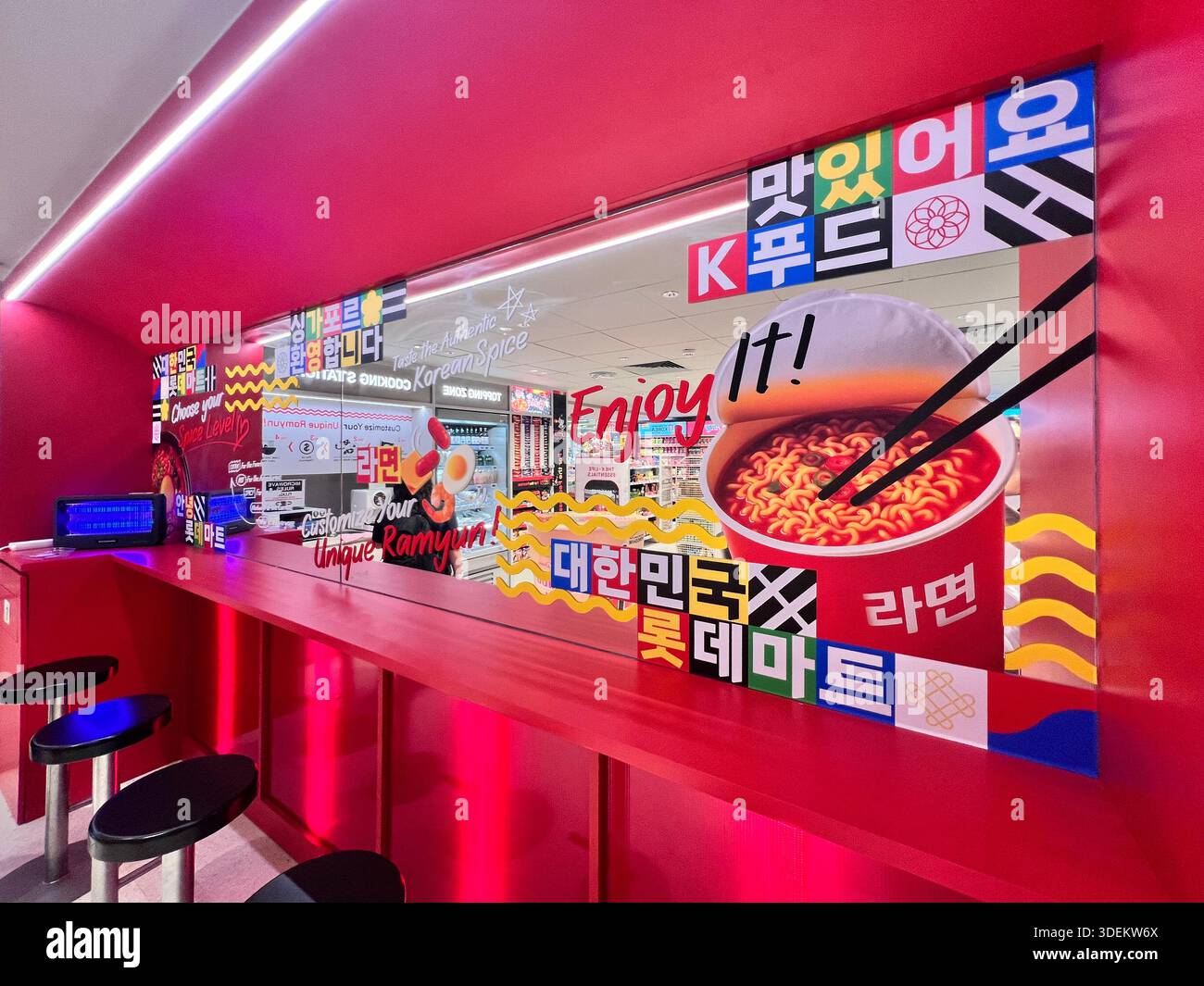Lotte Mart Express ouvre ses portes à Singapour. Les acheteurs peuvent manger leur ramyun ou leurs nouilles instantanées à la table supérieure rouge du bar. Desgin coloré pour attirer th Banque D'Images