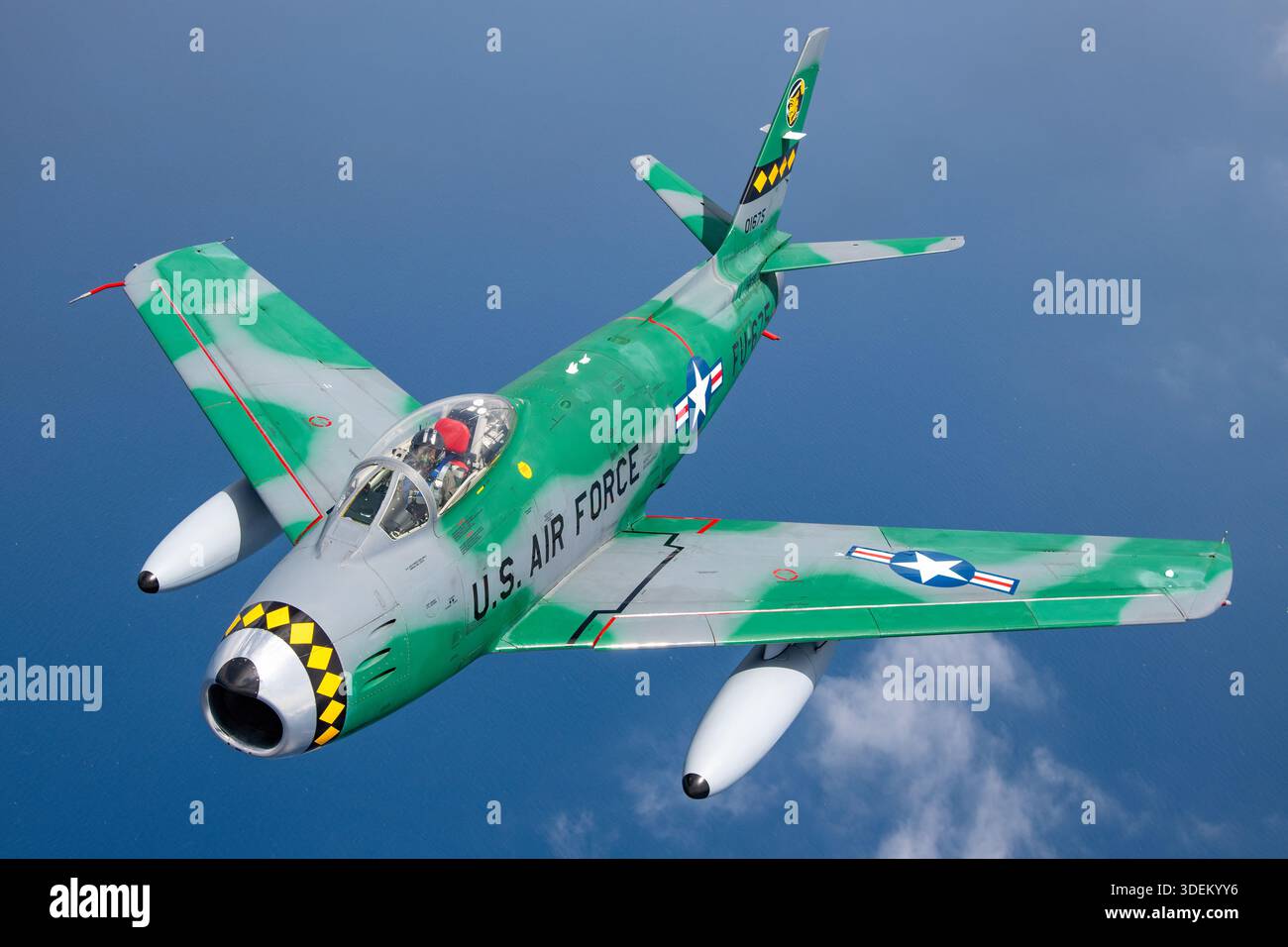 Cette image montre un chasseur Canadair CL-13B Sabre Mk.6 dans la peinture d'exposition de l'US Air Force volant air-air au Festival Aéreo Internacional AIRE AIRE 25 pendant le San Javier Airshow. Le Sabre Mk.6 est un chasseur monoplace à aile en flèche construit sous licence de North American Aviation par Canadair, propulsé par un seul turboréacteur Avro Canada Orenda 14 produisant une poussée de 7 275 lb, connu pour son rôle d'avion de supériorité aérienne de l'époque de la Guerre froide. Banque D'Images