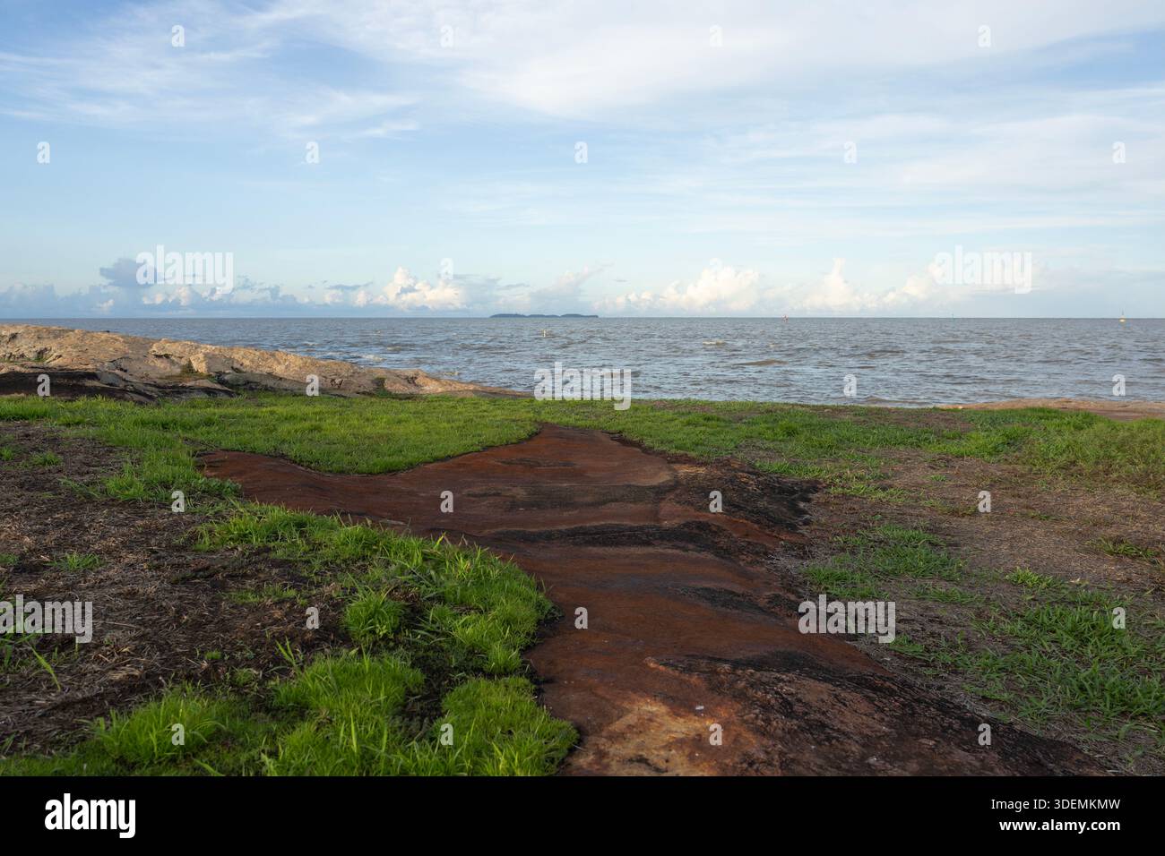 À Kourou, en Guyane française, une langue de roche volcanique pointe vers les îles du Salut à l’horizon où la France a installé une colonie pénitentiaire, fermée en 1946. Banque D'Images