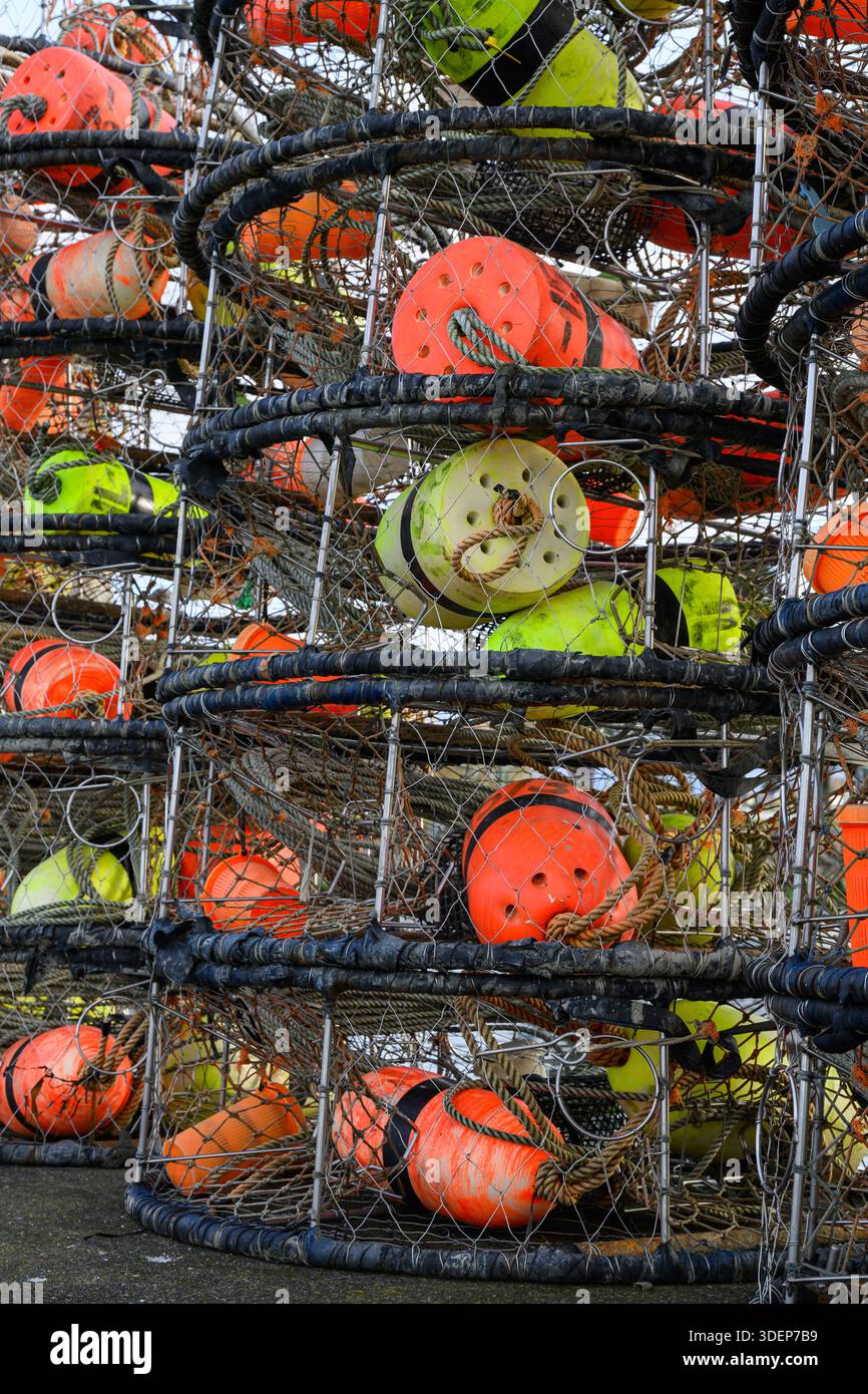 Gros plan de pile de pots de crabe de pêche avec des flotteurs colorés sur la jetée Banque D'Images