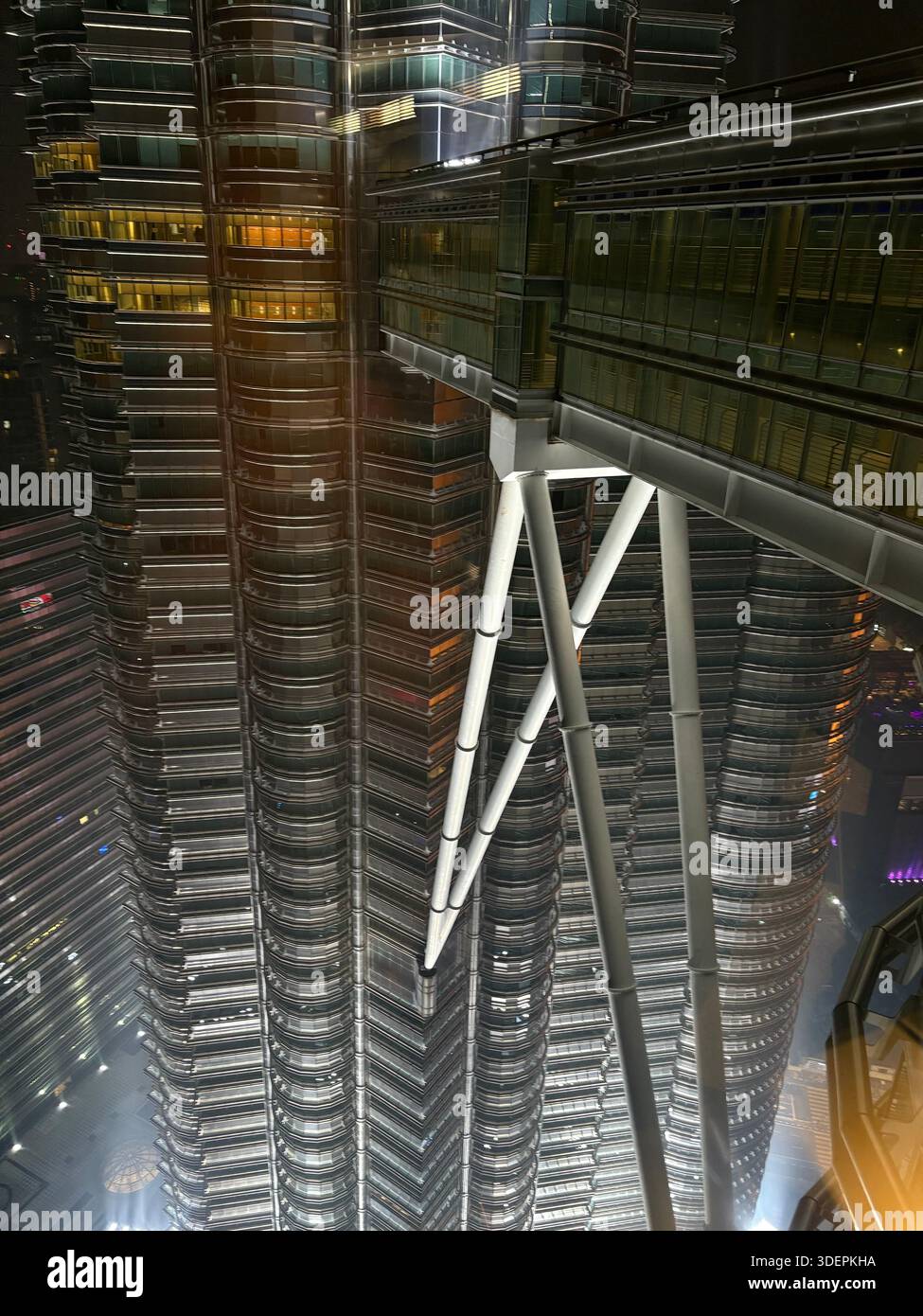 Vue nocturne du pont-ciel Petronas Twin Towers à Kuala Lumpur, Malaisie, avec structure en acier illuminée et façade moderne - Image de stock capturée avec un smartphone