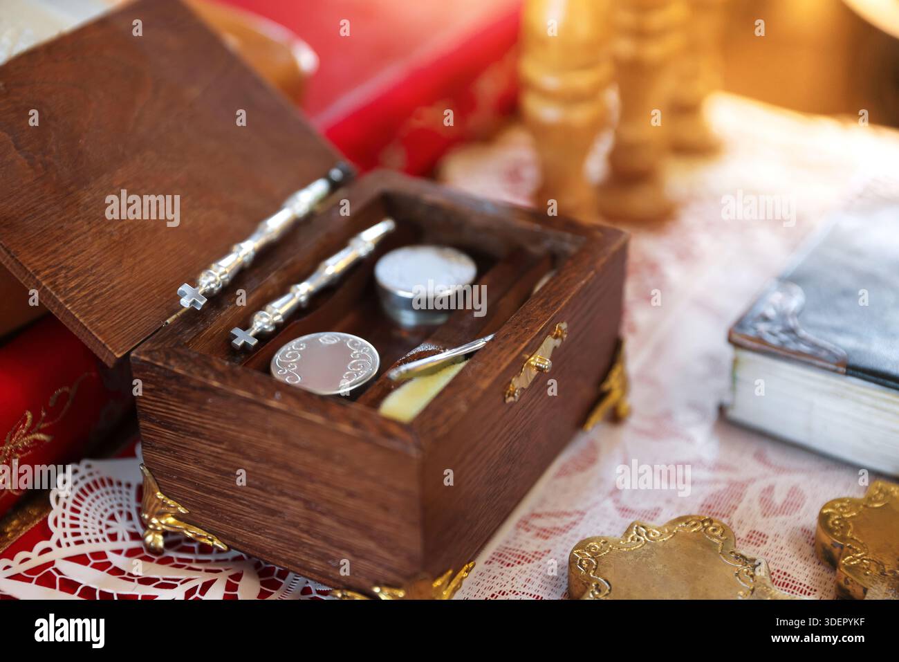 Cérémonie de baptême. Boîte en bois avec cuillères liturgiques et huile sacrée sur table dans l'église, gros plan Banque D'Images
