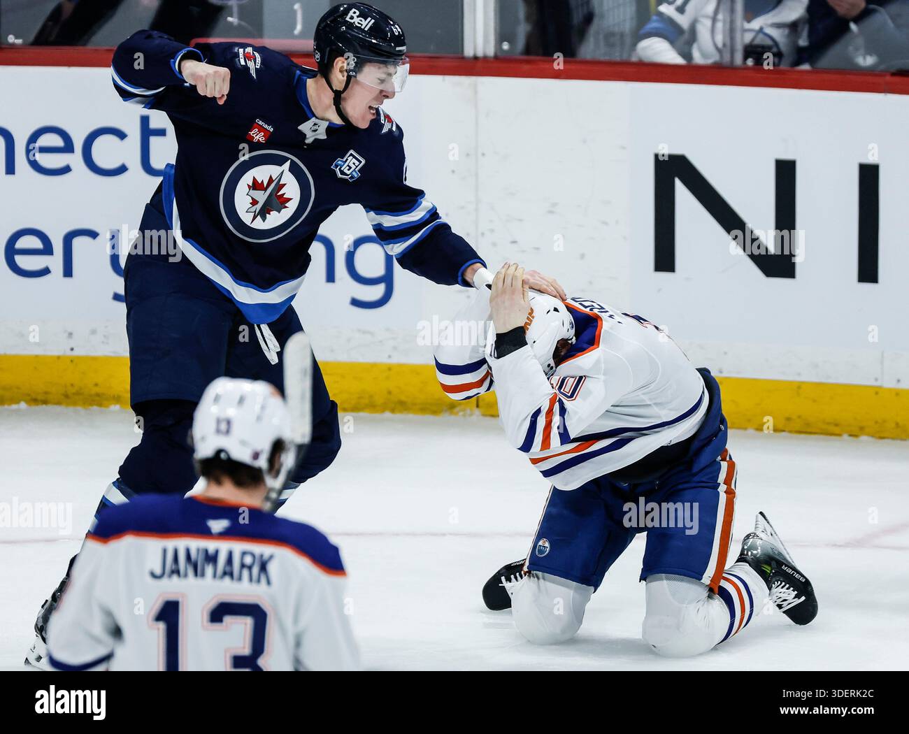 Edmonton Oilers' Trent Frederic (10) protects himself as he expects a punch from Winnipeg Jets' Logan Stanley (64) during second period NHL action in Winnipeg, Manitoba, Thursday, Jan. 8, 2026. (John Woods/The Canadian Press via AP) Banque D'Images