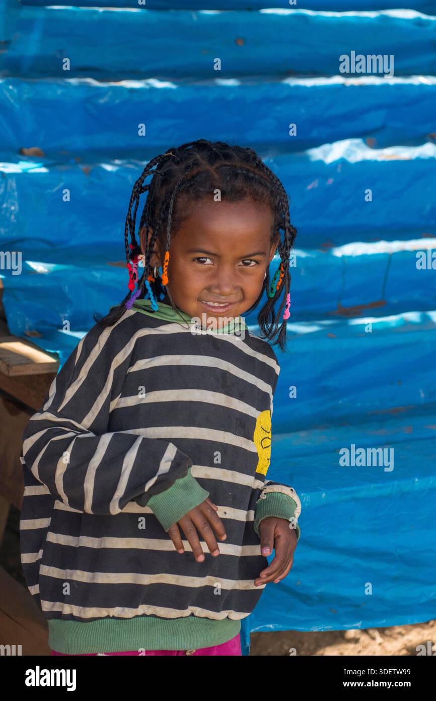 Portrait d'une jeune fille malgache à un étal de marché à côté de la route RN7 entre Ambohimandroso et Antsirabe, Madagascar. Banque D'Images