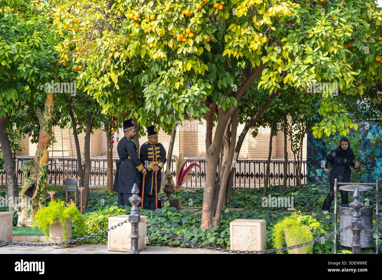 Cour persane traditionnelle avec orangers et gardes en uniforme Qajar à Zinat al-Molk House, Shiraz, Iran Banque D'Images